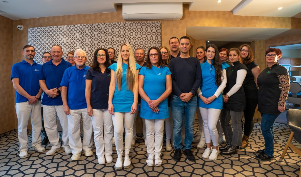 A KG Dental fogorvosai és munkatársai egy csoportképen a fogászat előterében.
