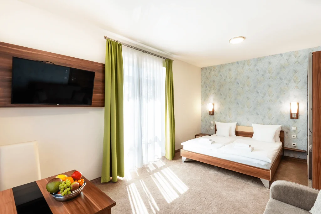 Hálószoba a Lajta Apartmanban franciaággyal TV-vel és erkélyajtóval.